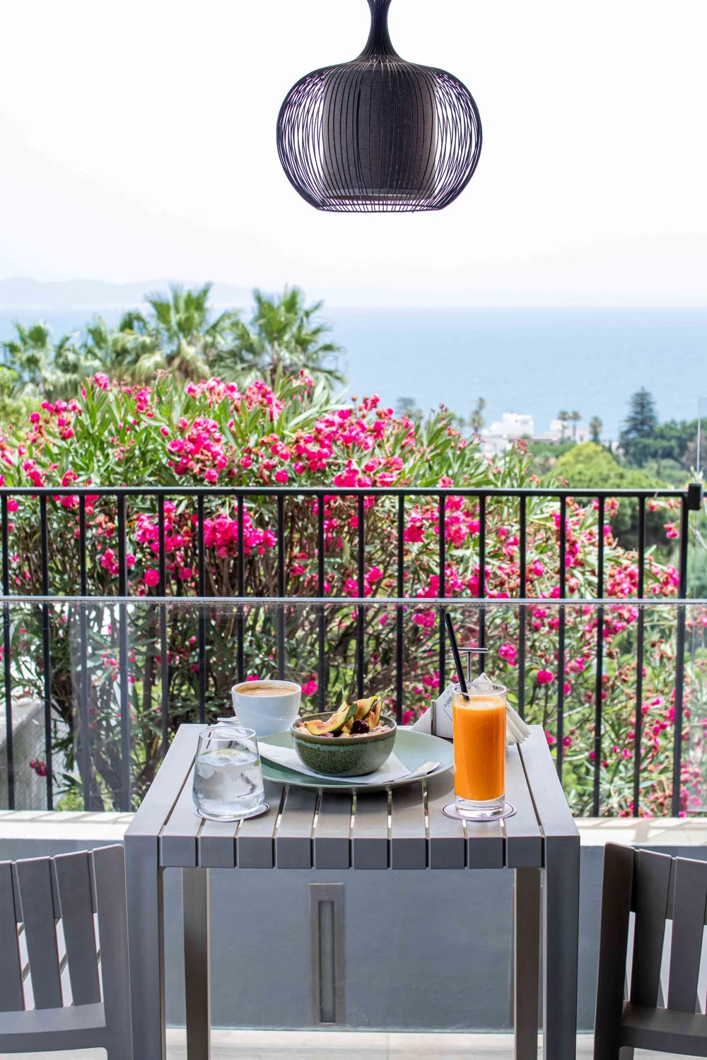 A bowl of fruit and a coffee facing the oleanders and the sea