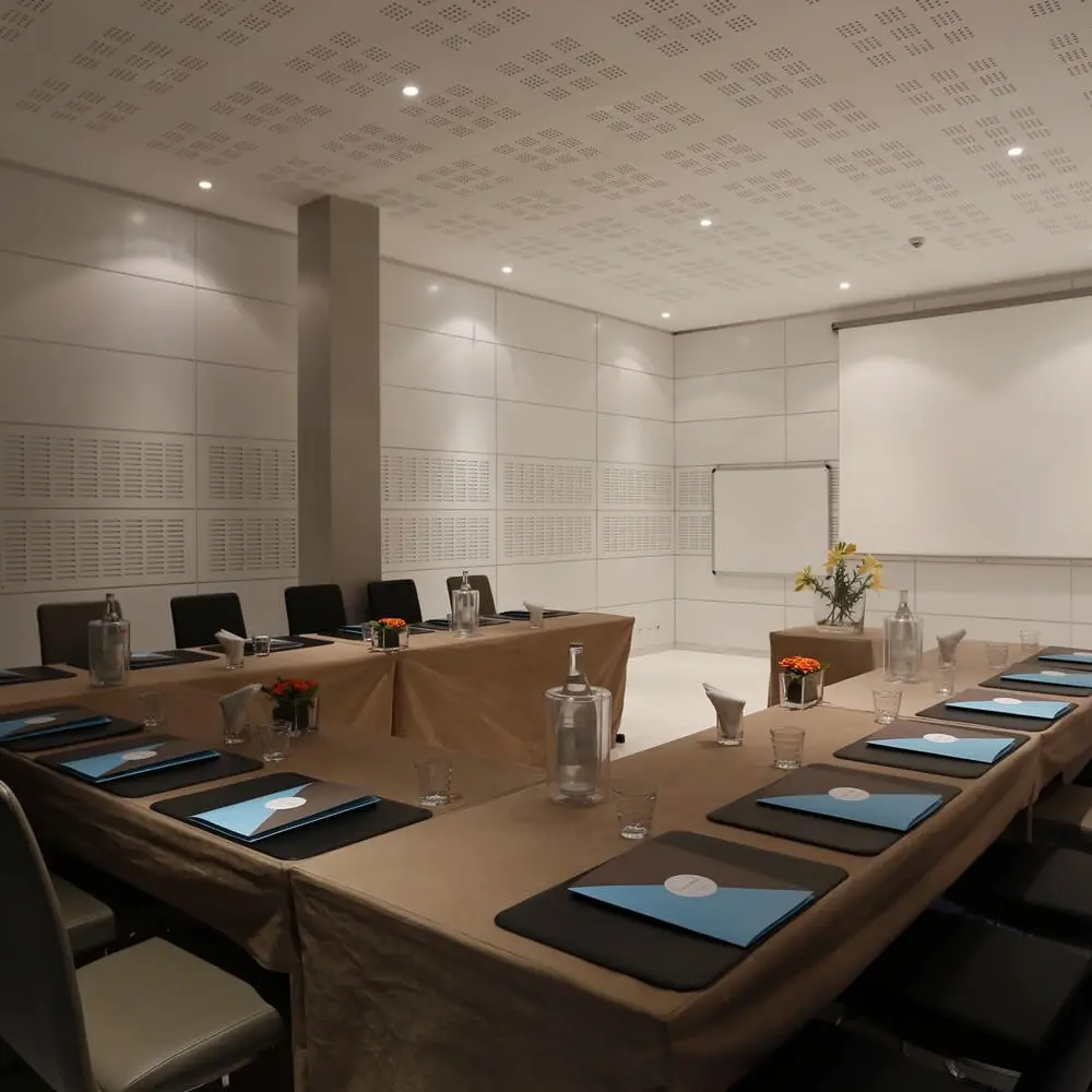 The room at Le Banquet set in a U-shape: pale linens, a folder at every place, projection screen and flipchart at the ready